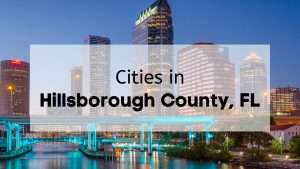 An up close view of a bridge and buildings in downtown Tampa at dusk with the text “cities in Hillsborough County”