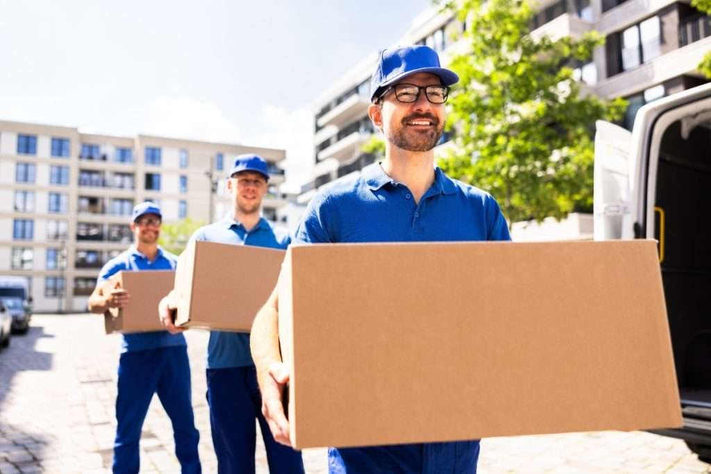 Three Tampa FL local movers in blue collared shirts carrying boxes